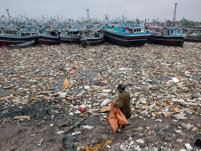 a boy looks for recyclable items in the polluted waters of karachi harbour pakistan photo reuters file a boy looks for recyclable items in the polluted waters of karachi harbour pakistan photo reuters file