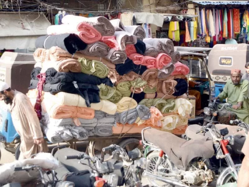 a labourers carries fabrics on a pushcart from a warehouse to shops at the wholesale cloth market on ma jinnah road photo express a labourers carries fabrics on a pushcart from a warehouse to shops at the wholesale cloth market on ma jinnah road photo express
