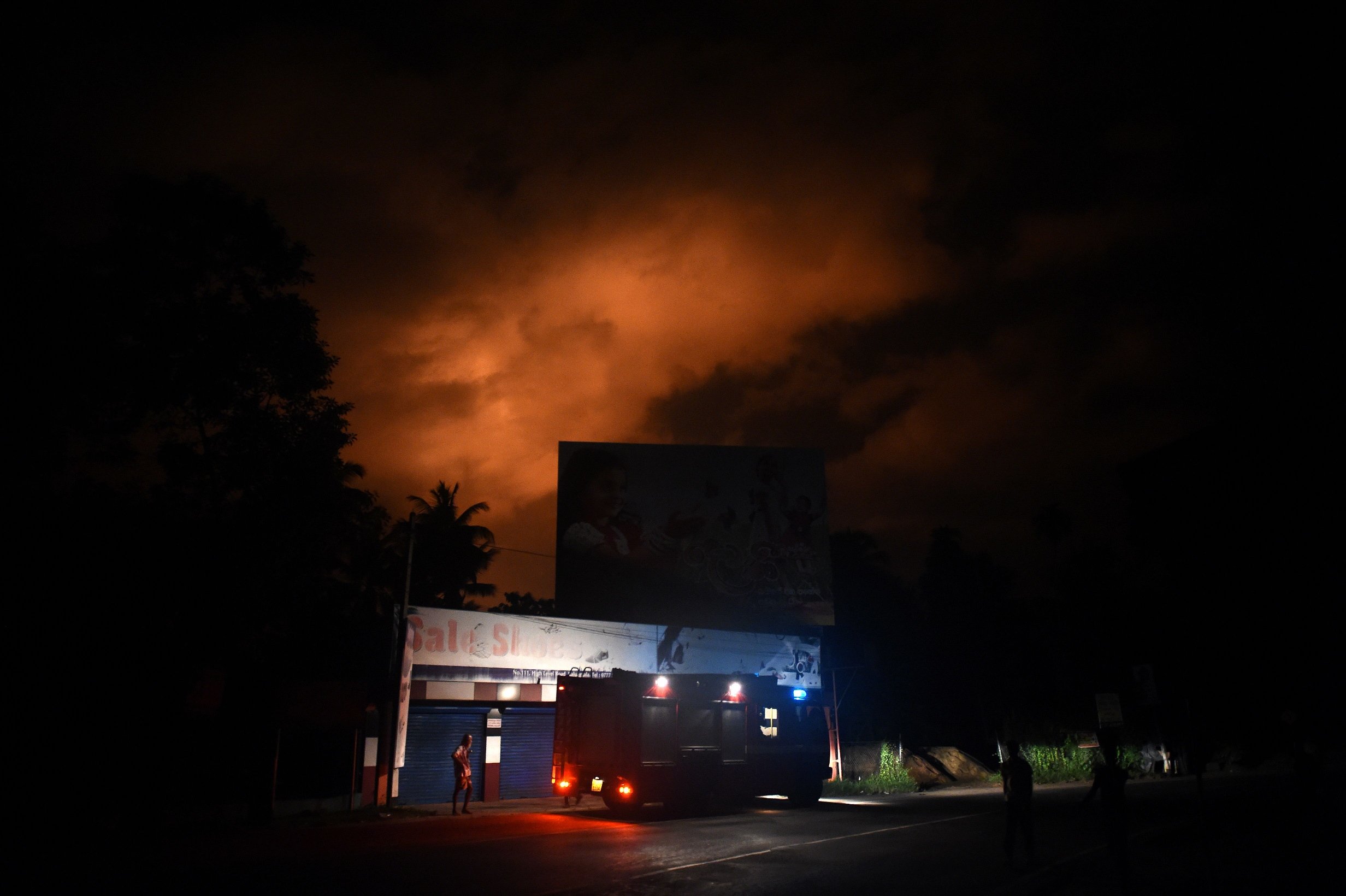 sri lankan firefighters watch from a distance as smoke and fire rise following explosions at an army ammunition dump at salawa military camp on the outskirts of colombo on june 5 2016 photo afp