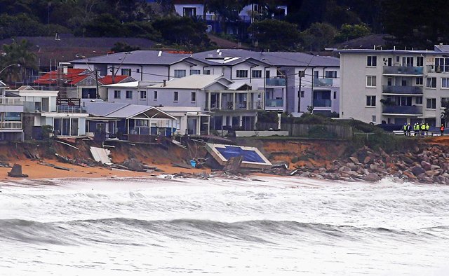 officials stand near a swimming pool and houses that suffered damage after severe weather that brought strong winds and heavy rain to the east coast of australia at collaroy beach in sydney australia june 6 2016 photo reuters