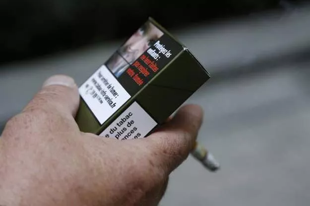a man smokes a cigarette on september 25 2014 in paris holding a sample of a plain cigarette packaging cigarette box photo afp a man smokes a cigarette on september 25 2014 in paris holding a sample of a plain cigarette packaging cigarette box photo afp