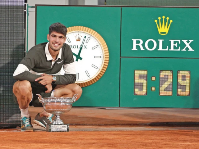 spain s carlos alcaraz poses with the trophy next to the clock that shows the duration of the match the longest for a final in roland garros against italy s jannik sinner after winning the french open photo afp spain s carlos alcaraz poses with the trophy next to the clock that shows the duration of the match the longest for a final in roland garros against italy s jannik sinner after winning the french open photo afp