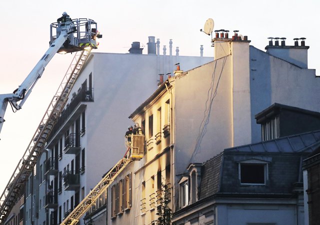 firemen stand in an aerial bucket to extinguish a fire in a building on june 6 2016 in saint denis near paris a fire broke out on june 6 2016 evening in a residential building in central saint denis causing seven wounded two seriously according to concordant sources afp photo