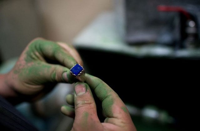 an afghan student works on a lapis lazuli ring during a jewellery class in kabul photo afp