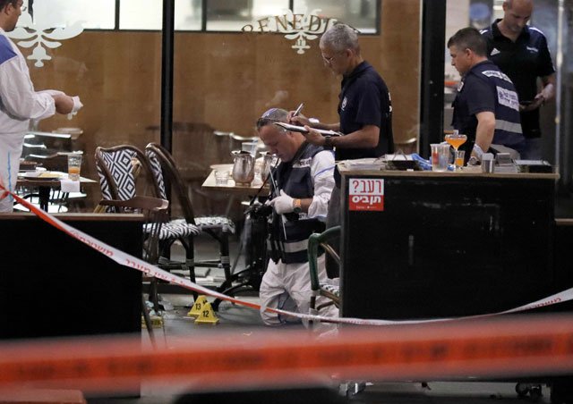 israeli forensic police inspect a restaurant following a shooting attack at a shopping complex in the mediterranean coastal city of tel aviv on june 8 2016 photo afp