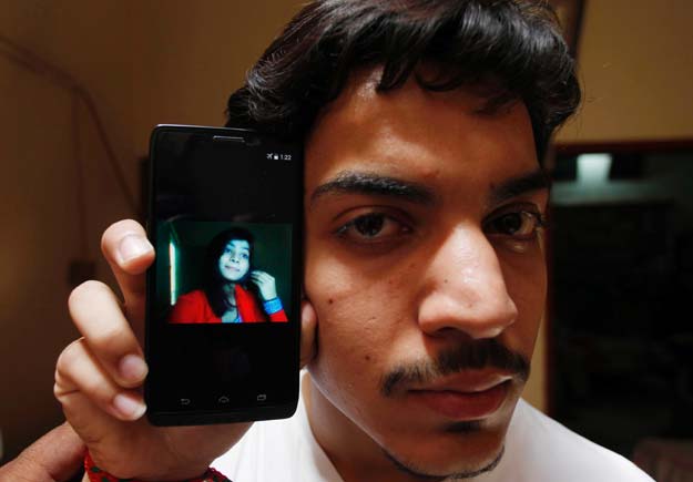 hassan khan shows the picture of his wife zeenat bibi who was burnt alive by her mother on his cellphone at his residence in lahore on june 8 2016 photo afp