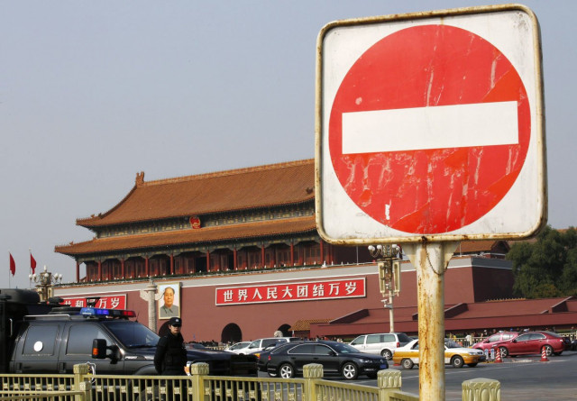 a sign is seen next to a policeman of the special weapons and tactics swat team standing guard in front of the giant portrait of chinese late chairman mao zedong on tiananmen square in beijing october 30 2013 photo reuters a sign is seen next to a policeman of the special weapons and tactics swat team standing guard in front of the giant portrait of chinese late chairman mao zedong on tiananmen square in beijing october 30 2013 photo reuters
