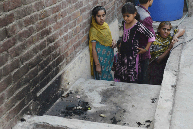 in this photograph taken on june 8 2016 residents stand at the site where a teenager was burnt alive by her mother in lahore photo afp file