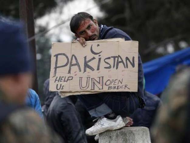 a migrant from pakistan holds a placard while waiting to cross the border from greece into macedonia near gevgelija macedonia november 26 2015 photo reuters