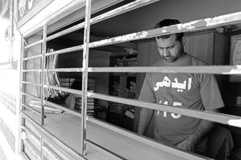 an attendant stands at the reception where people come to register bodies above a special desk has been set up by the cplc at the edhi morgue to identify bodies below photos ayesha mir express