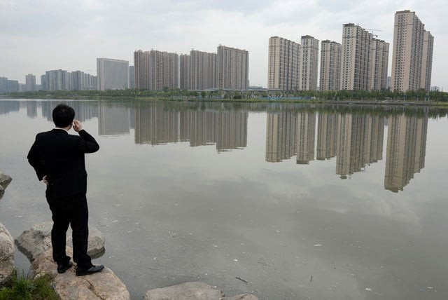 a man talks on his phone near a new residential compound in taiyuan shanxi province may 11 2014 photo reuters a man talks on his phone near a new residential compound in taiyuan shanxi province may 11 2014 photo reuters