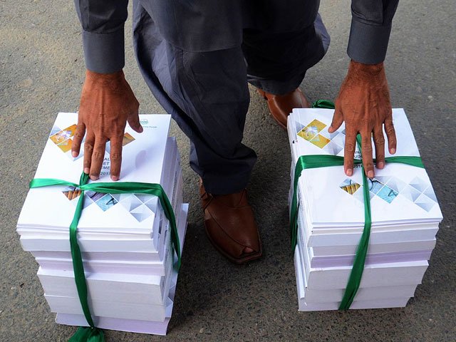 a man is seen carrying copies of punjab budget for financial year 2016 17 outside punjab assembly on june 13 2016 photo online