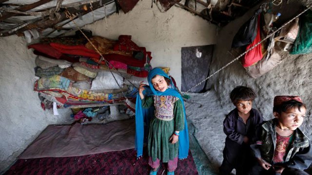 internally displaced afghan children stand inside their shelter at a refugee camp in kabul afghanistan photo reuters