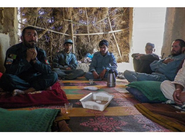 in this photograph taken on april 28 2016 afghan police commander seddiqullah 30 l sits alongside his subordinates as he speaks during an interview with afp at a checkpoint in tarin kot capital of southern uruzgan province photo afp