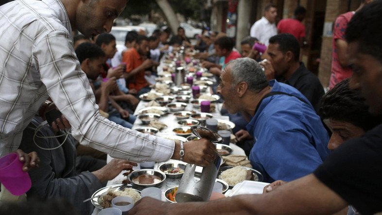 people eat iftar the breaking of fast meal served for free on quot charity tables quot on a street during the first day of the holy month of ramadan in cairo june 29 2014 photo reuters