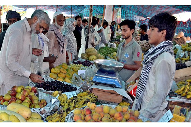 a large number of people purchasing fruits at sasta ramazan bazaar photo app