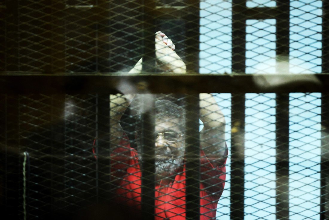 egypt 039 s ousted islamist president mohamed morsi back wearing a red uniform looks on from behind the defendant 039 s bars during his trial on espionage charges at a court in cairo on june 18 2016 photo afp