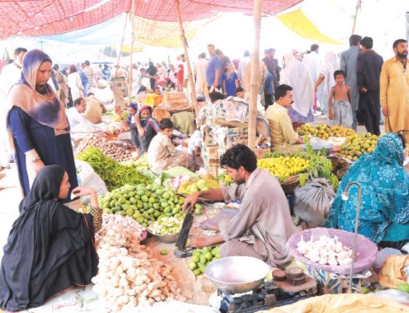 a woman checks fruit at a ramazan bazaar photo express