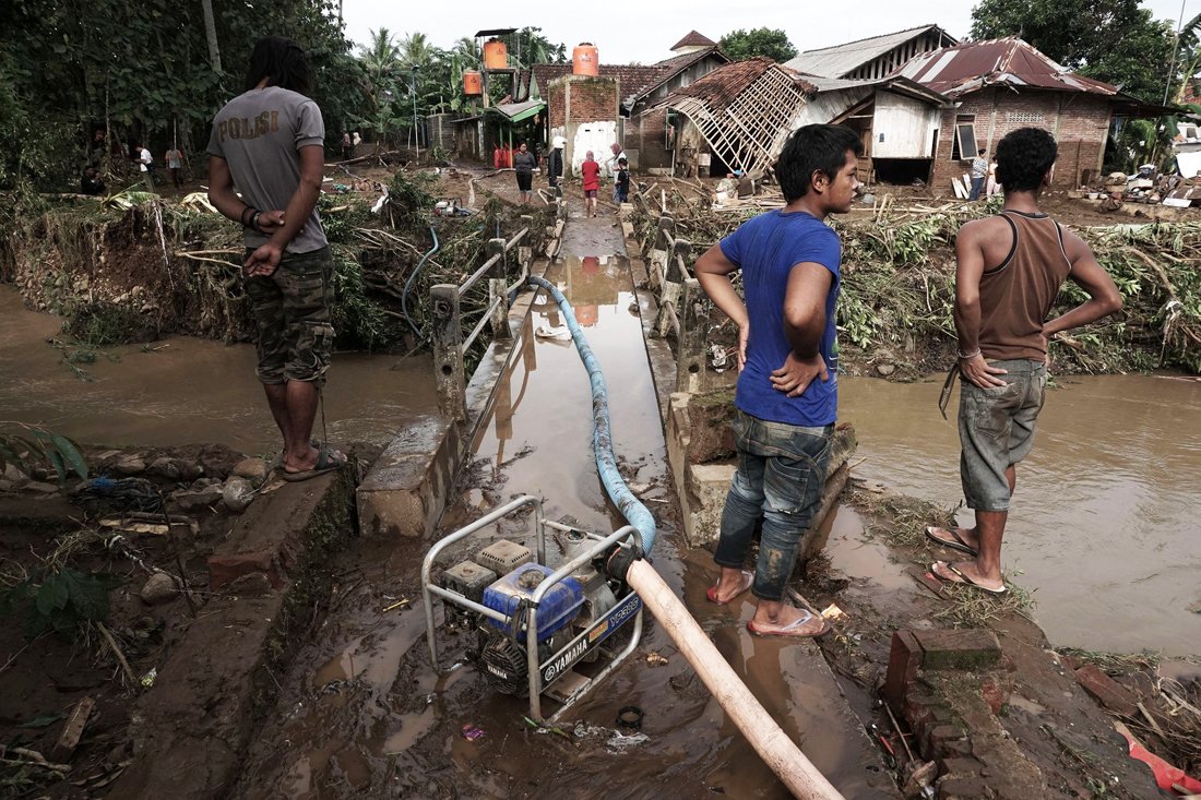indonesian villagers look on after waters receded following flash floods in kamulyan village in banyumas central java on june 19 2016 photo afp