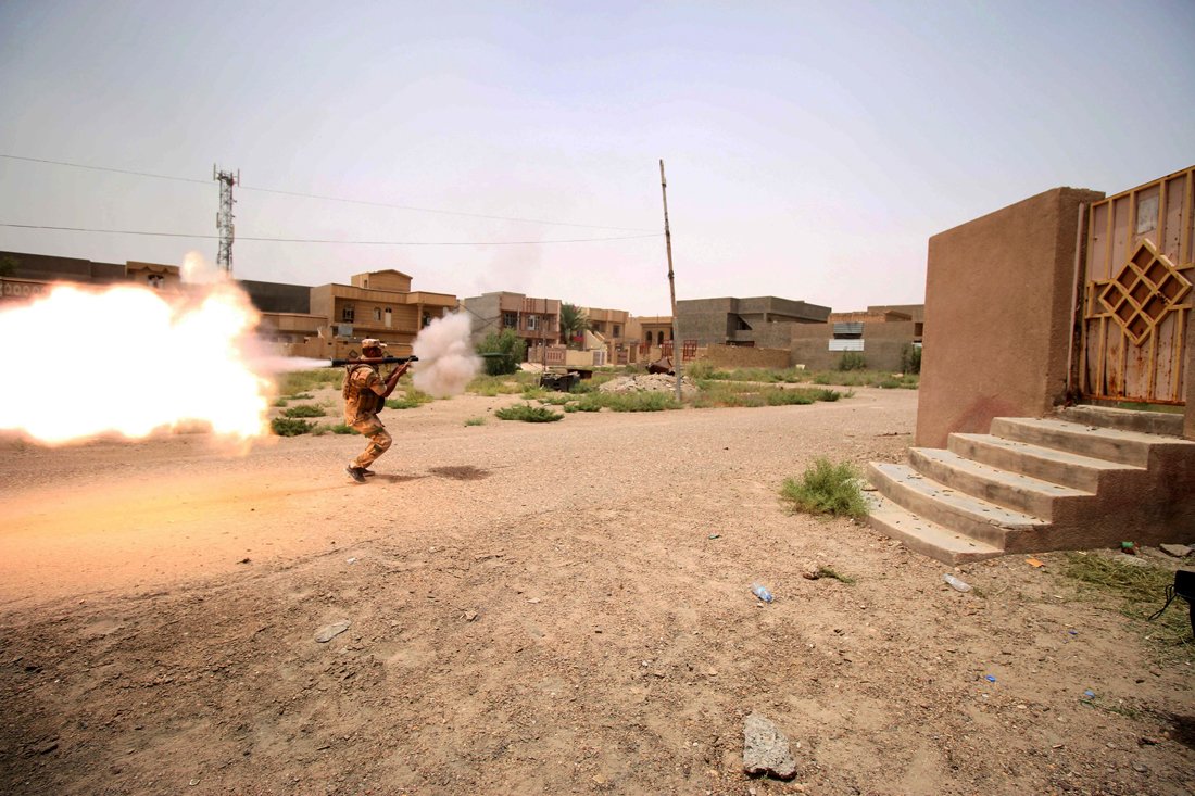 a member of the iraqi pro government forces fires a rocket propelled grenade during clashes with islamic state is group fighters as they try to enter the eastern askari neighbourhood of fallujah during a military operation to clear the city of is fighters still holed up in the former jihadi bastion on june 19 2016 photo afp