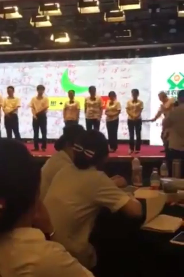 the video showed eight employees four men and four women lined up on a stage and being asked by a man why they came last in a competition screen grab the video showed eight employees four men and four women lined up on a stage and being asked by a man why they came last in a competition screen grab