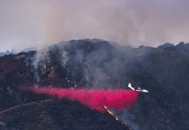 an aircraft drops fire redartant to prevent the advance of the san gabriel complex fire in the angeles national forest near duarte on june 21 2016 photo afp