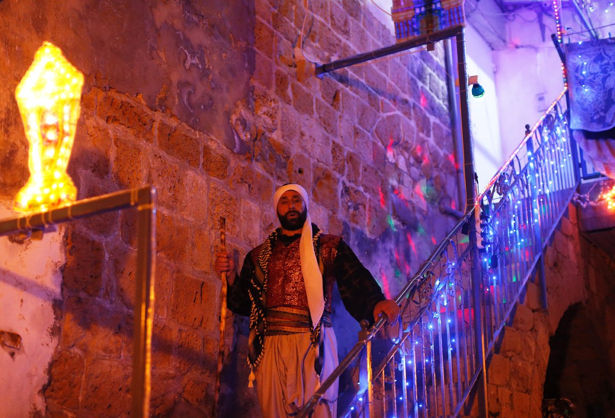 michel ayoub an arab israeli christian man carrying out the role of a quot musaharati quot the traditional figure who awakens muslims for the quot suhur quot the pre dawn traditional meal before muslims start their fast during the sacred month of ramadan walks in the street rousing muslim residents in the northern israeli port city of acre on june 16 2016 photo afp