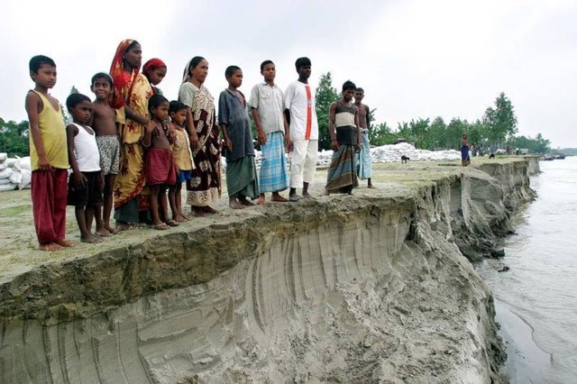 in this july 2004 file photo bangladeshis look at the erosion left by the river jamuna in sariakandi near bogra town 250 km northwest of the capital dhaka photo reuters