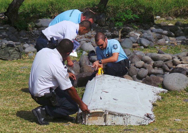 french gendarmes and police inspecting a large piece of plane debris which was found on the beach in saint andre on the french indian ocean island of la reunion july 29 2015 photo reuters