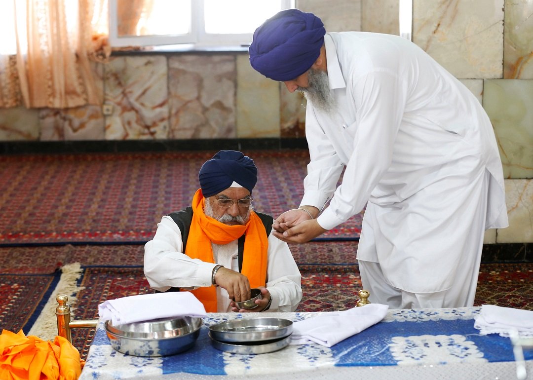 an afghan sikh r receives karah prasad a sweet pudding offering given out to a congregation at the end of prayer inside a gurudwara photo reuters