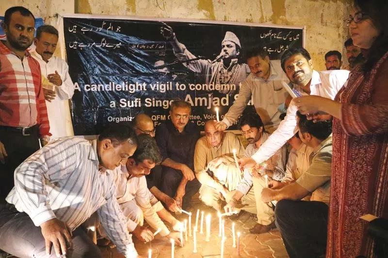 javed qazi qurrat mirza and other participants light candles on a footpath outside karachi press club on thursday photo express javed qazi qurrat mirza and other participants light candles on a footpath outside karachi press club on thursday photo express