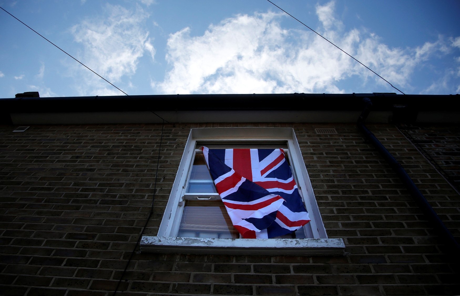 a british flag flutters in front of a window in london britain june 24 2016 after britain voted to leave the european union in the eu brexit referendum photo reuters