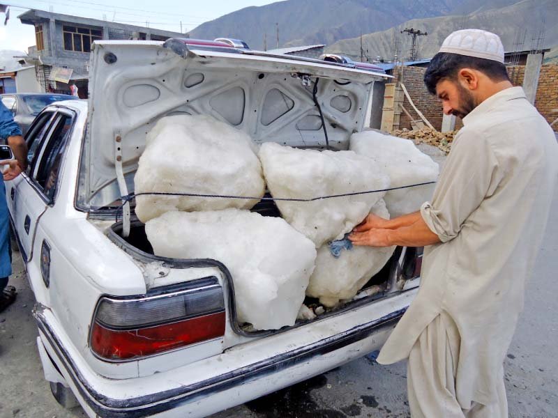 a man takes out pieces of melted ice glaciers from the peak of trich mir to chitral city photos express