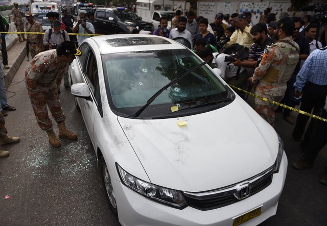 security officials gather around the bullet riddled car of qawwali maestro amjad sabri who was killed in an attack by unknown gunmen in karachi on june 22 2016 photo afp