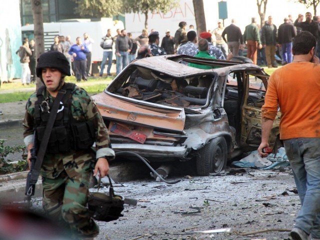 a lebanese soldier walks away from a destroyed taxi cab at the scene of a car bomb explosion that rocked central beirut on december 27 2013 photo afp
