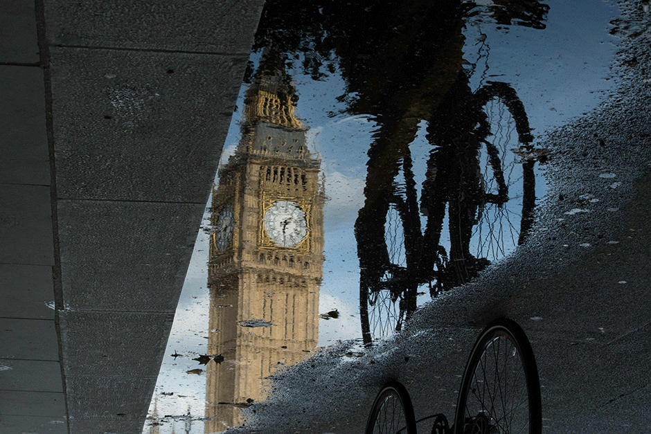 the queen elizabeth tower big ben is reflected in a puddle as a cyclist rides by in london britain began preparations to leave the european union on monday but said it would not be rushed into a quick exit as markets plunged in the wake of a seismic referendum despite attempts to calm jitters photo afp