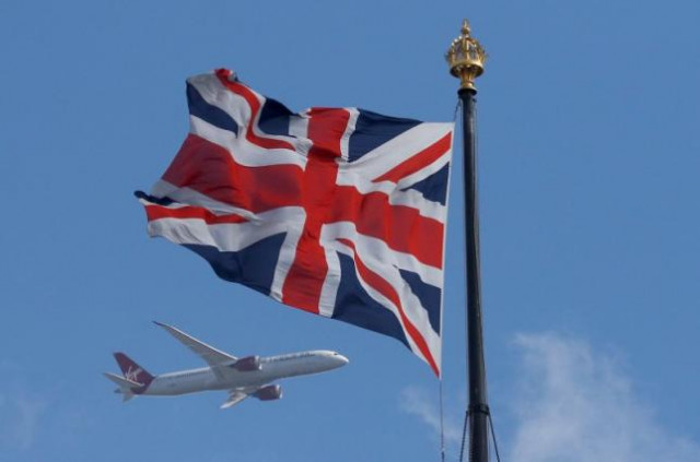 a virgin atlantic passenger jet flies past the union flag above the houses of parliament in westminster in central london britain photo reuters
