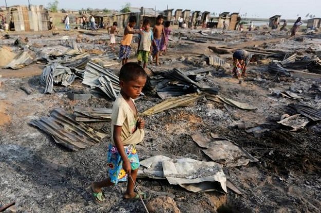 a boy walks among debris after fire destroyed shelters at a camp for internally displaced rohingya muslims photo reuters