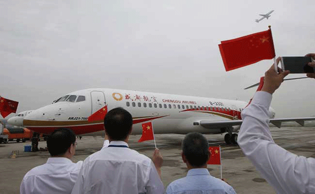 people wave chinese flags as an arj21 700 china 039 s first domestically produced regional jet arrives at shanghai hongqiao airport after making its first flight from chengdu to shanghai on june 28 2016 photo afp