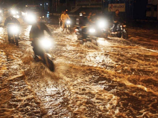 motorcyclists drive through rainwater accumulated on ma jinnah road photo online motorcyclists drive through rainwater accumulated on ma jinnah road photo online