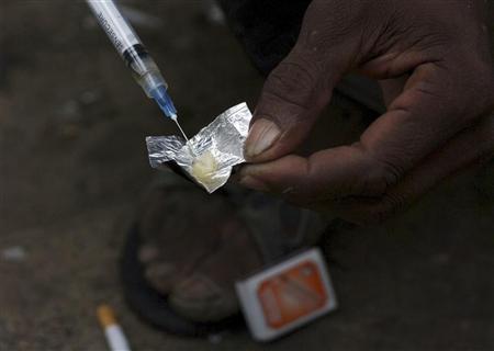 a syringe sucks up a mixture of heroin and water prepared on a foil wrap as addicts shoot up in a 2009 file photo photo reuters