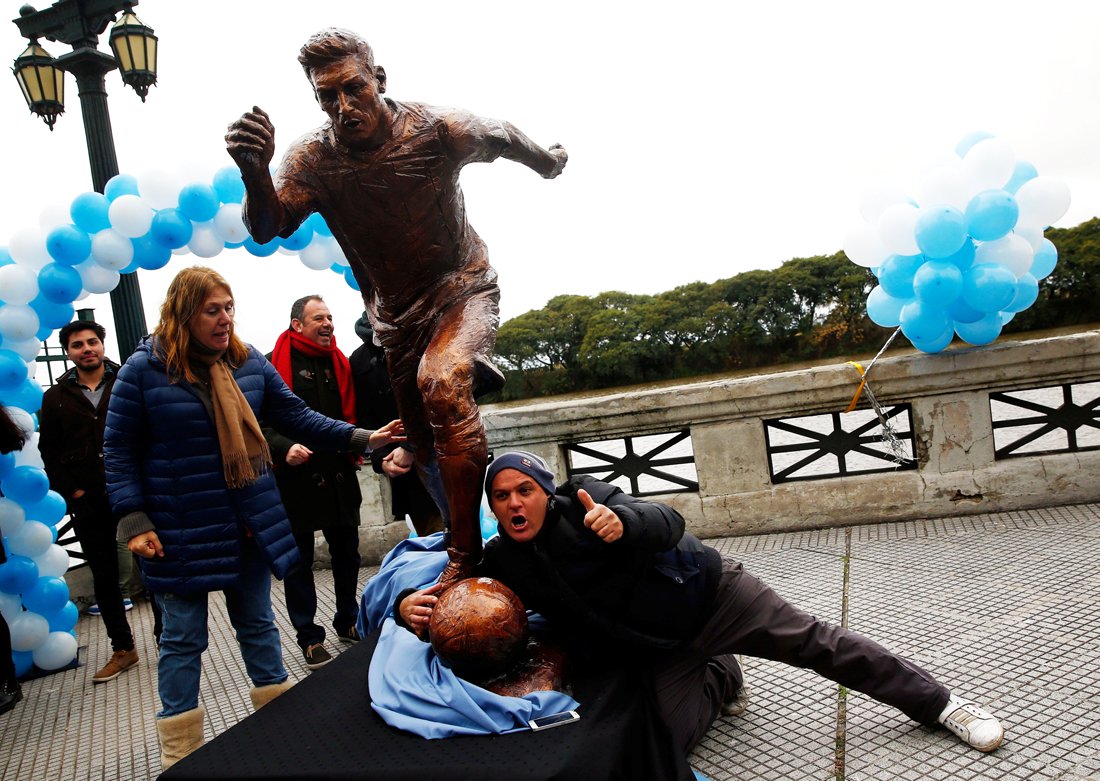 a man gestures as he grabs the statue of argentina 039 s soccer player lionel messi after it was unveiled in buenos aires argentina june 28 2016 photo reuters