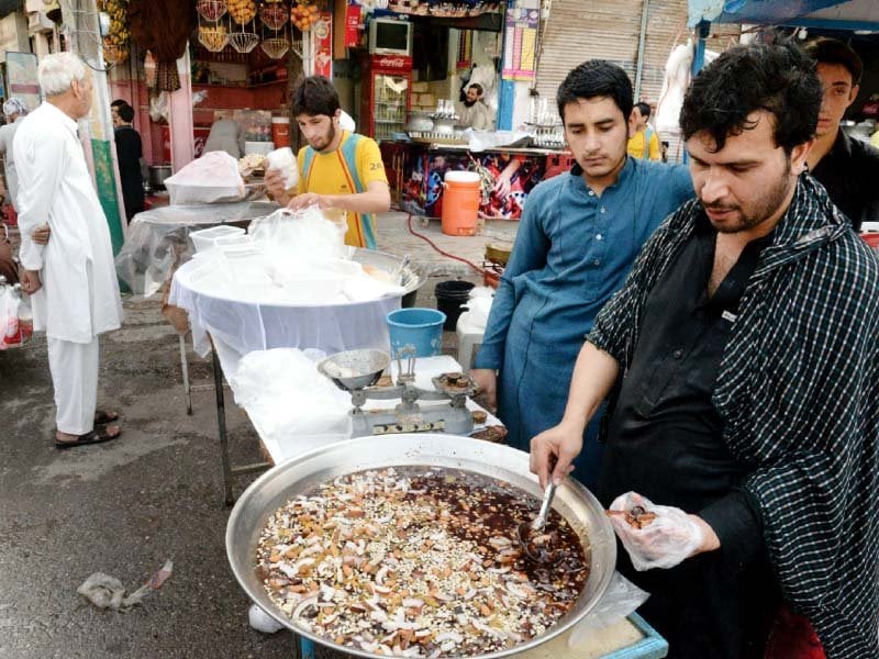 a man prepares dishes at the food street photo muhammad iqbal express