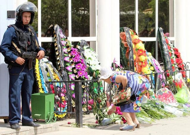 a woman places flowers outside the firearms shop which was a target of a recent suspected militant attack during the funeral of salesman andrey maksimenko in aktobe kazakhstan june 8 2016 photo reuters