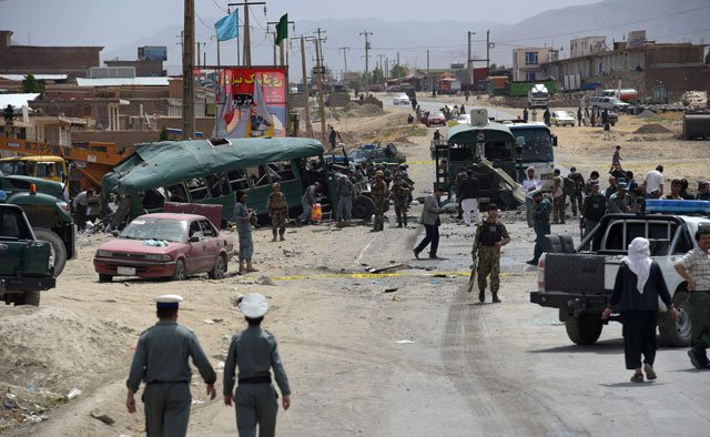 afghan security personnel gather near the wreckage of buses which were carrying police cadets at the site of a bomb attack on the outskirts of kabul on june 30 2016 photo afp