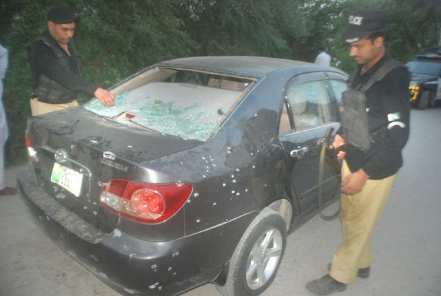 policemen inspect the car that came under attack in the bashirabad area of peshawar city on thursday photo express