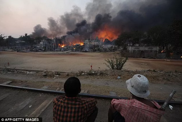 riots two residents sit on a railway track as a mosque burns in riot hit meikhtila central myanmar riots two residents sit on a railway track as a mosque burns in riot hit meikhtila central myanmar