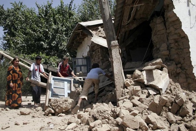 a villager remove debris from their house destroyed by an earthquake photo reuters