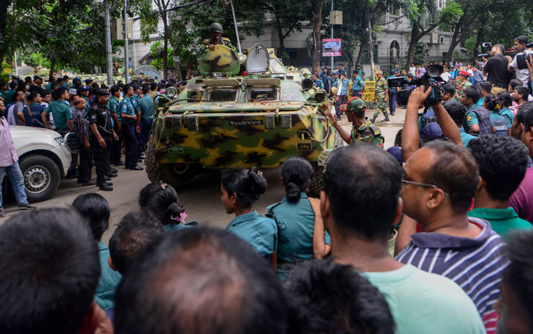 a bangladeshi armoured military tank makes its way past journalists onlookers and police near an upscale restaurant in dhaka on july 2 2016 following a bloody siege by armed attackers that began on july 1 photo afp