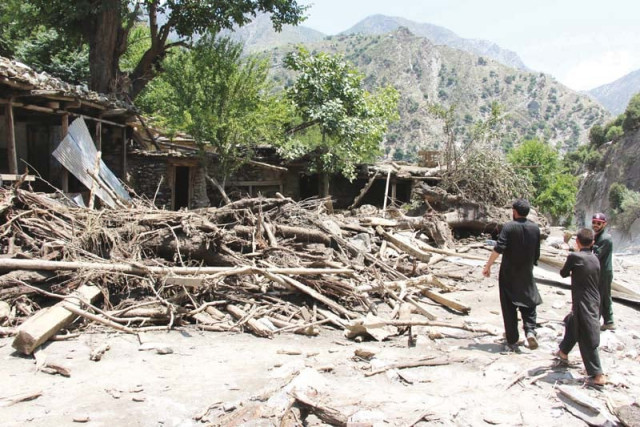 residents gather around damaged houses in ursoon village in chitral photo afp residents gather around damaged houses in ursoon village in chitral photo afp